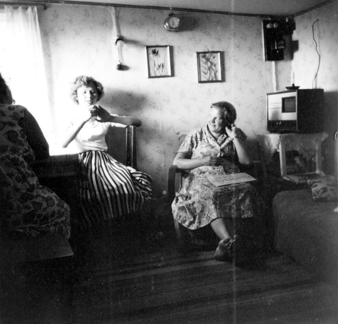 Dos mujeres sentadas en una sala de los años cincuenta escuchando la radio